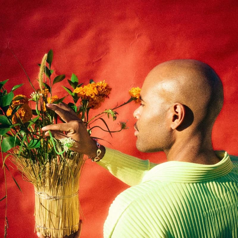 A floral arrangement and a portrait in a lime-green sweater